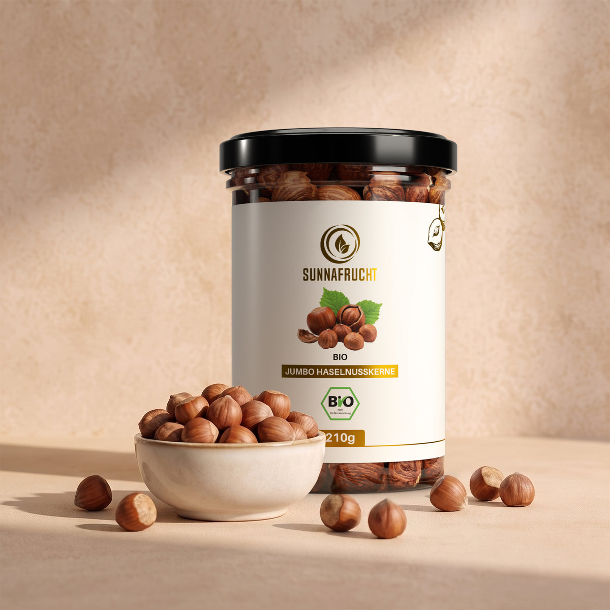 Bio Haselnusskerne von Sunnafrucht in der Klarsichtdose mit einer Schale Haselnüsse