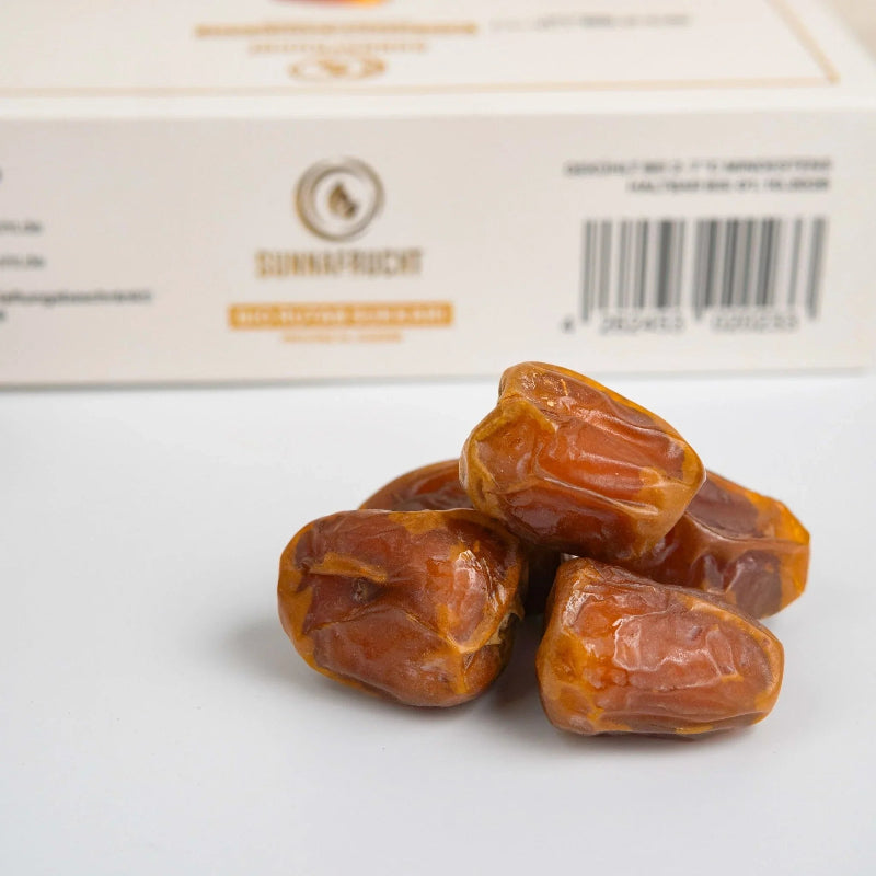 Bio Sukkari Datteln vor heller Verpackung, Nahaufnahme, Premium Trockenfrüchte