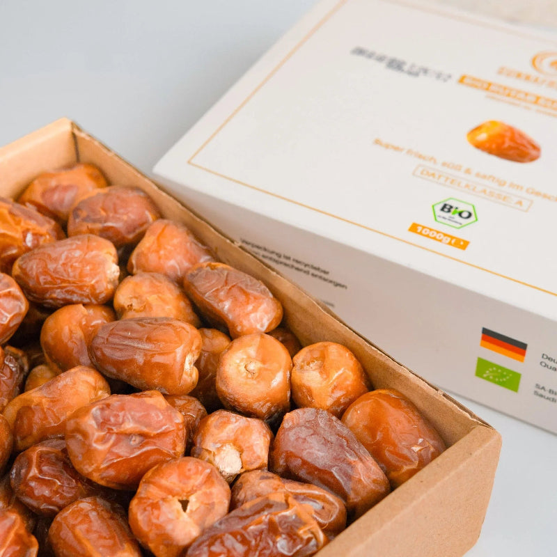 Bio Rutab Sukkari Datteln in geöffneter Kartonschachtel neben Produktverpackung, naturbelassen
