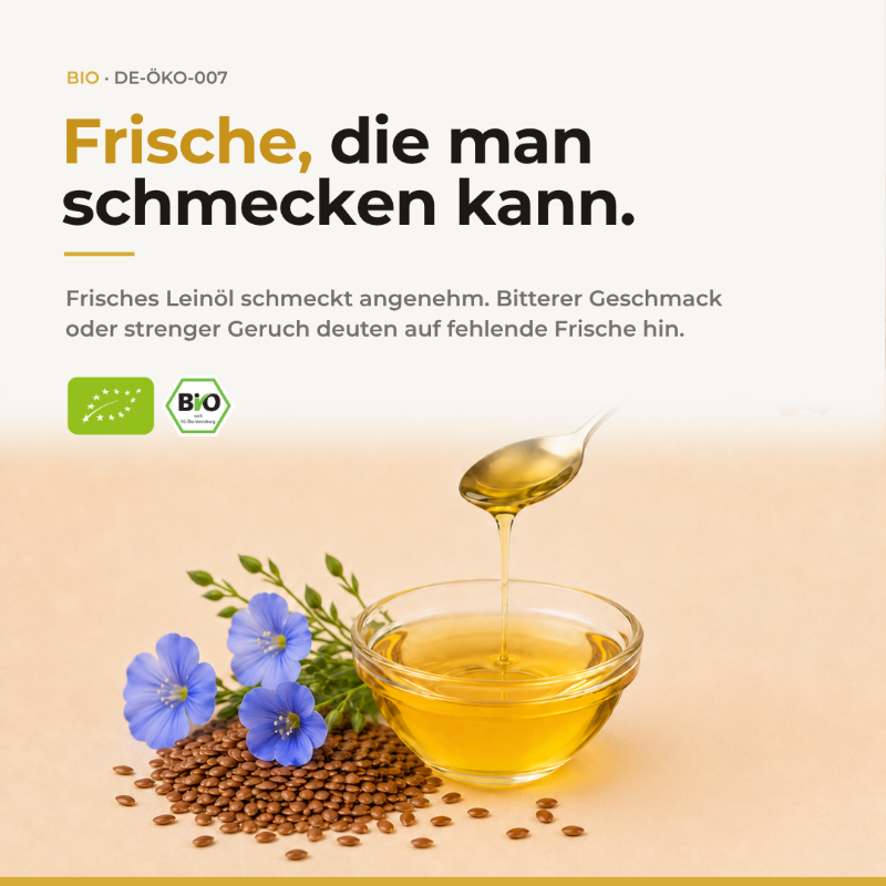 Frische beim Bio Leinsamenöl: goldgelbes Öl in Glasschale mit Löffel, blauen Leinblüten und Leinsamen