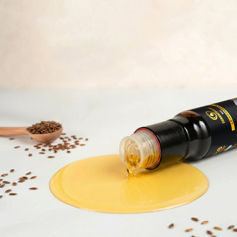 Offene Bio Leinsamenöl Flasche liegt mit ausgelaufenem goldgelbem Öl, daneben Leinsamen und Holzlöffel