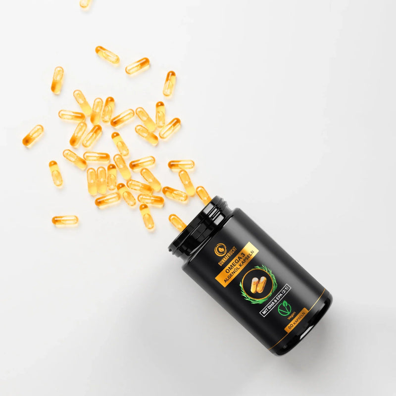 Geöffnete Dose Omega 3 Algenöl Kapseln mit ausgeschütteten goldgelben Kapseln auf weißem Untergrund