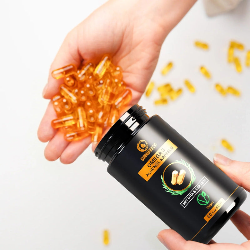 Hand schüttet Omega 3 Algenöl Kapseln aus der Dose in die Handfläche