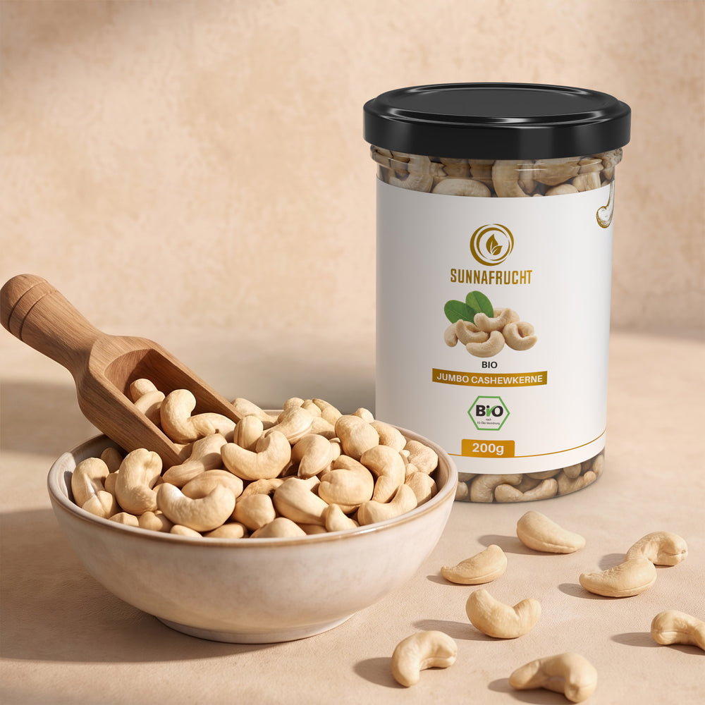 Keramikschale mit ganzen Cashewkernen und Holzschaufel, dahinter die Dose Bio Cashewkerne 200 g