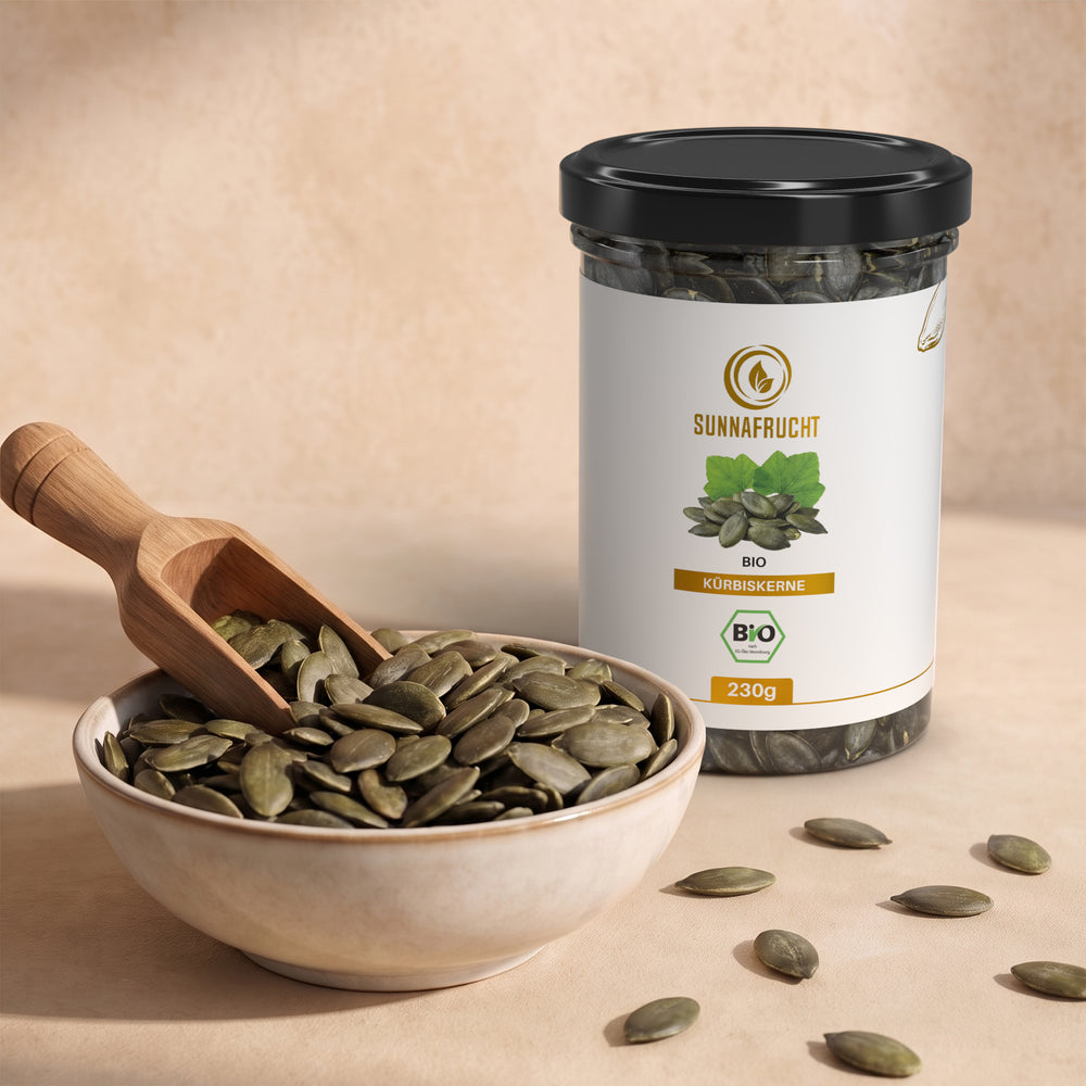 Keramikschale mit grünen Kürbiskernen und Holzschaufel, dahinter die Dose Bio Kürbiskerne 230 g