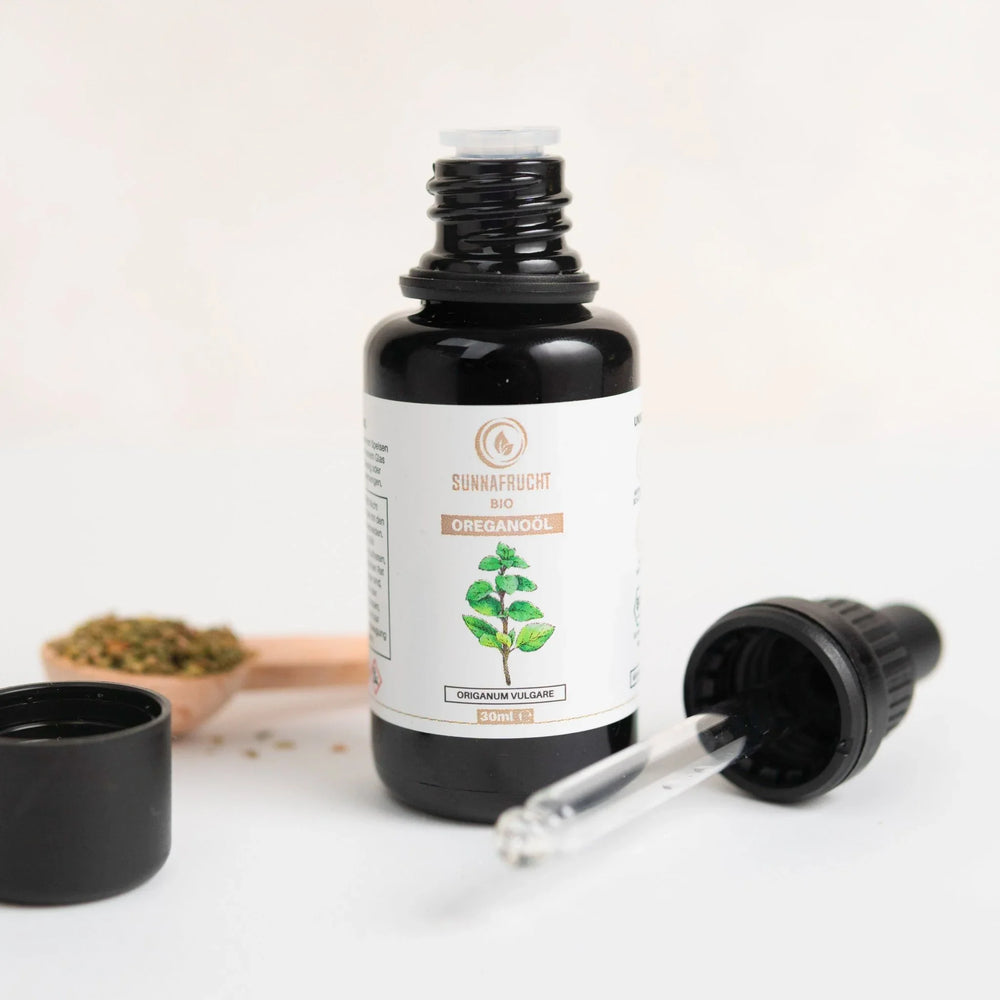Bio Oreganoöl in dunkler Glasflasche mit Pipette, 30ml, Kräuter im Hintergrund